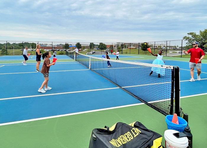 Kids play tennis on a tennis court