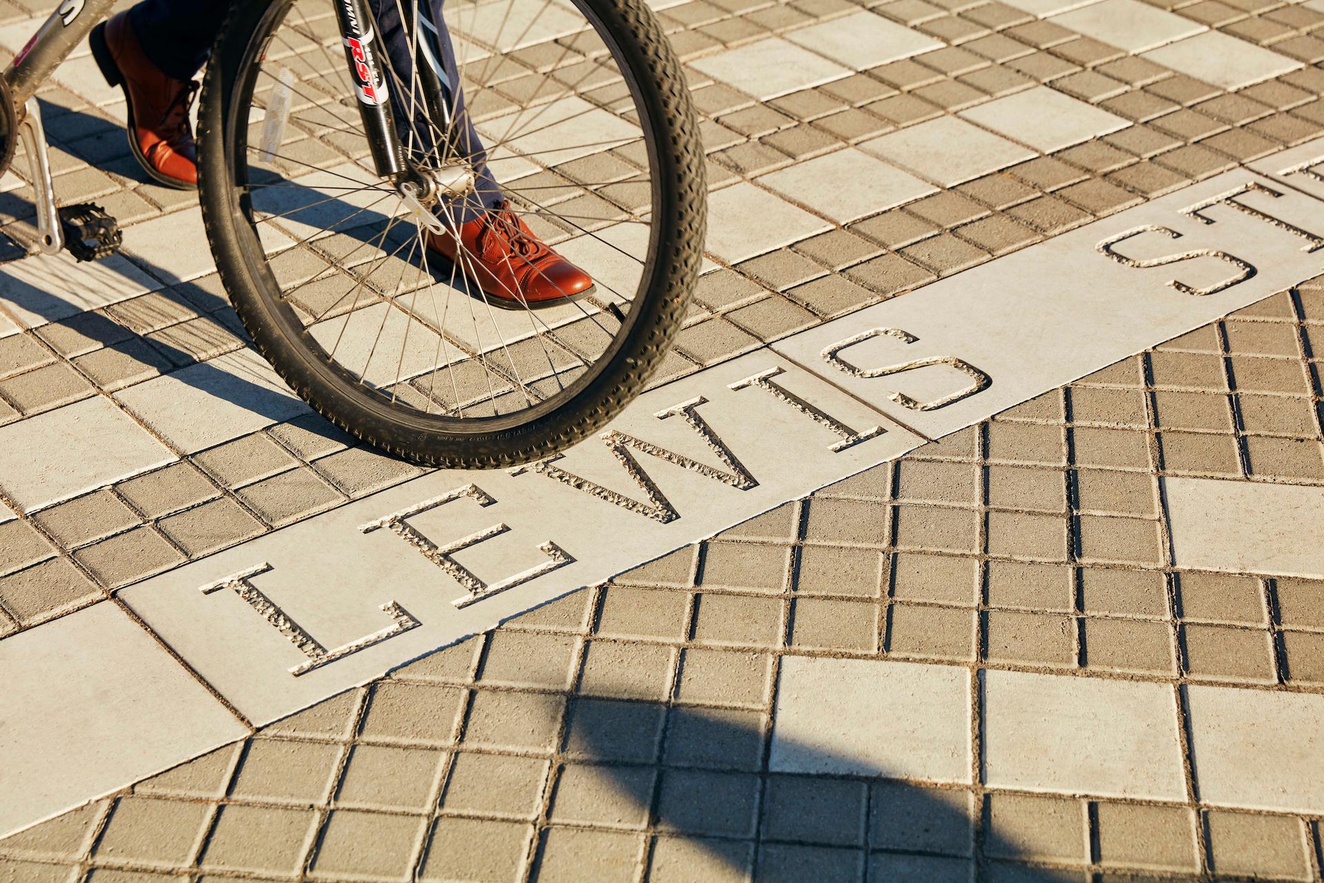 A bike wheel stopped at a decorative sidewalk.