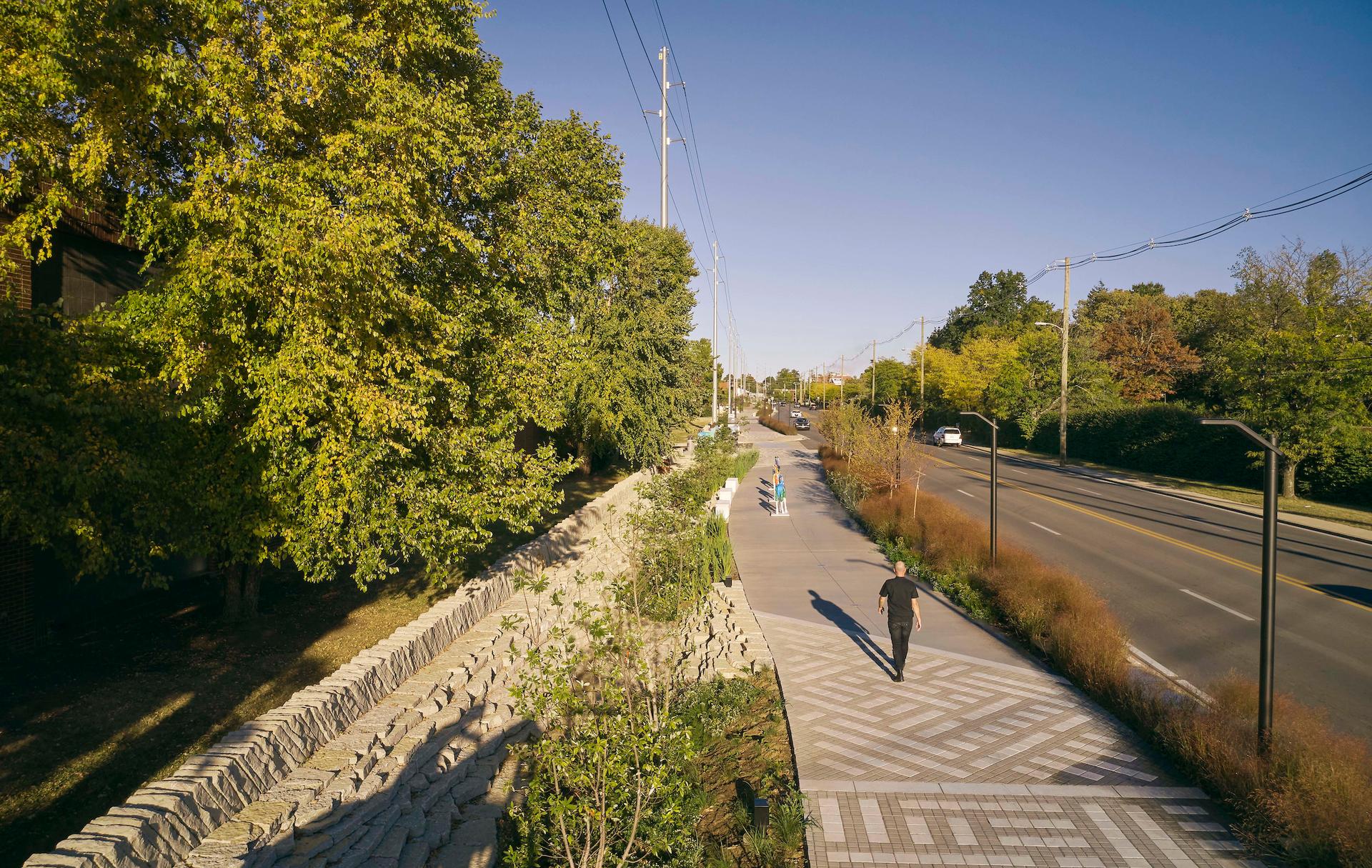 A person walks along Town Branch Commons. 