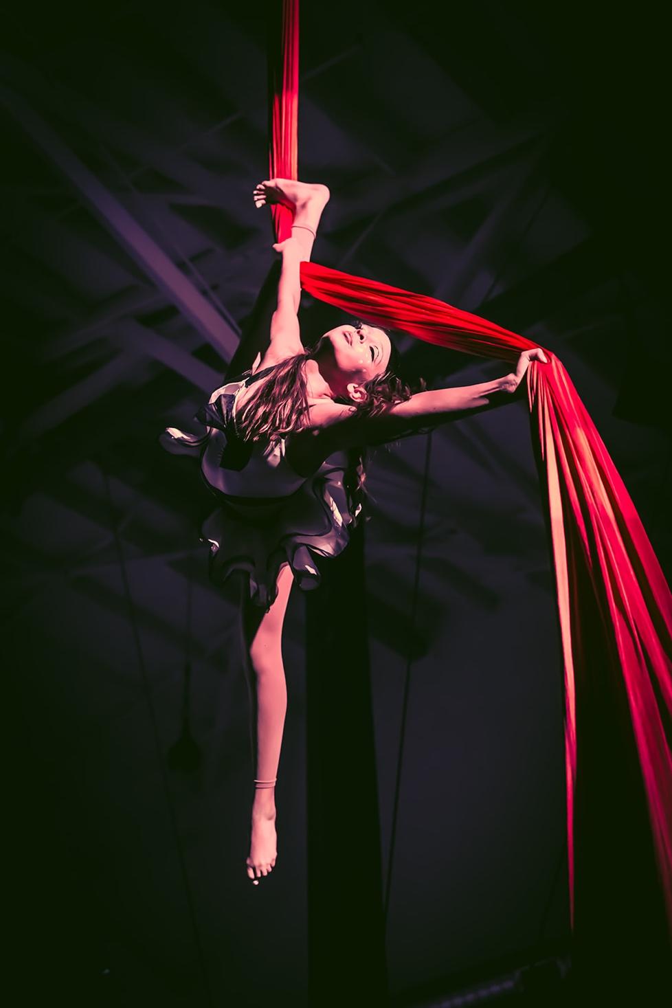 Aerial artist spinning with a red rope